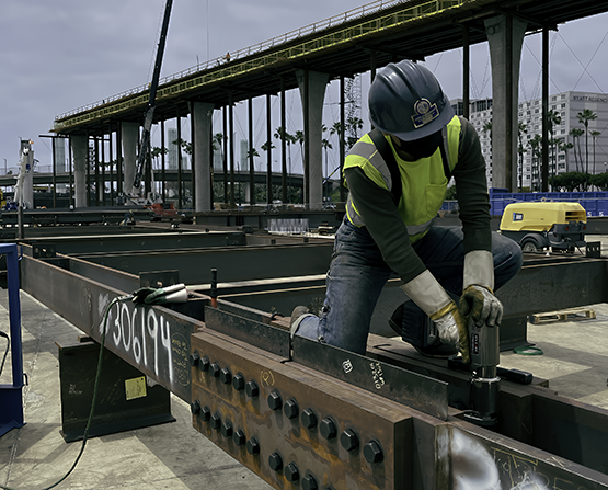 A worker installing bolts using a LITHIUM Series II Electric Torque Tool