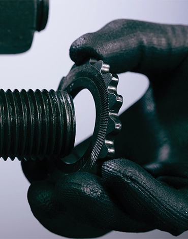 A person installing the J-Washer, a washer with a dual-face locking mechanism that prevents pinch points and loosening from vibration.