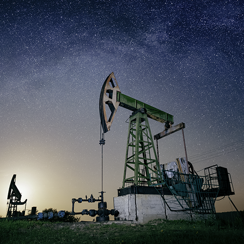 Heavy machinery operating in a field at night.